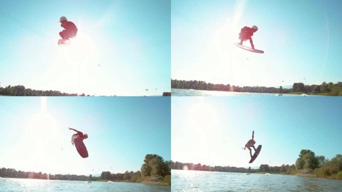 镜头耀斑: 极端的滑水运动员在晴朗的蓝天上跳跃和旋转。