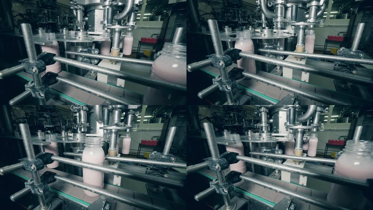 装满瓶子的奶制品厂在生产线上移动。生产和包装食品和饮料的自动化设备。