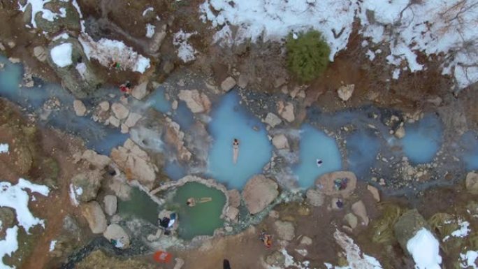 无人机徒步旅行者在寒冷的绿松石池中洗个澡