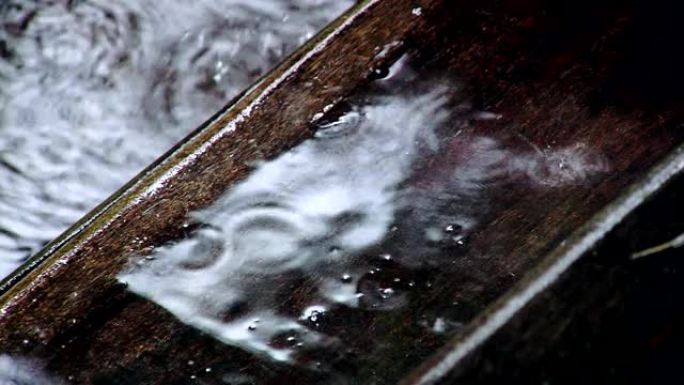 雨滴落在木质甲板地板上。