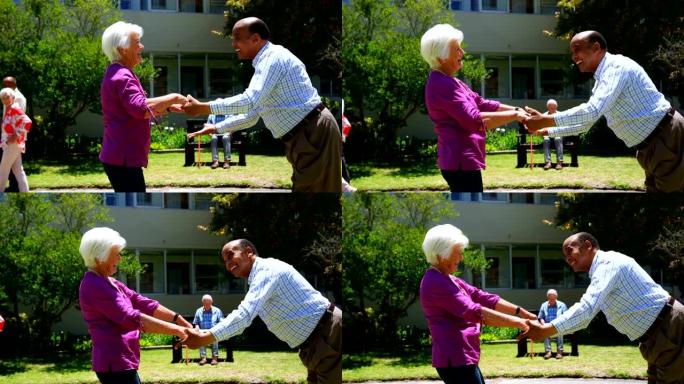活跃的混血夫妇在养老院4k花园里一起跳舞的侧视图