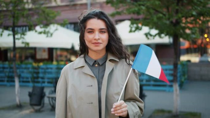 慢动作肖像可爱的法国女孩站在户外与法国国旗