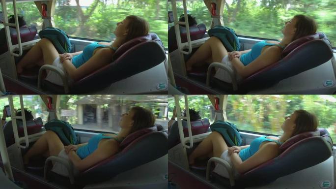 特写: 年轻的女旅行者在卧铺巴士上开车时睡得很紧。