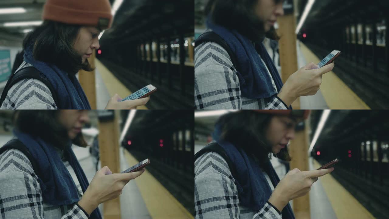 在地铁平台上使用智能手机的旅游妇女