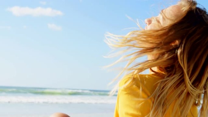 年轻的白人妇女在海滩上摇头的侧视图4k
