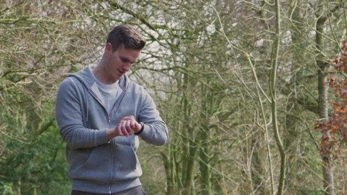 男子在农村跑步锻炼检查智能手表健身活动应用