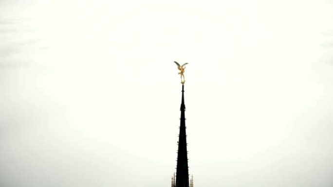 无人机在史诗般的天堂城堡尖顶圣米歇尔山附近飞行，金色雕像在云层上方。