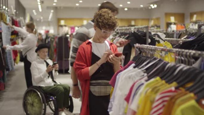 自信的女人在服装店的轮椅上购物