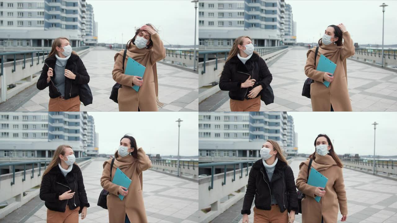 两名年轻的医生妇女戴着口罩在空旷的风城街上行走。流行病检疫上的恐惧和危险气氛。