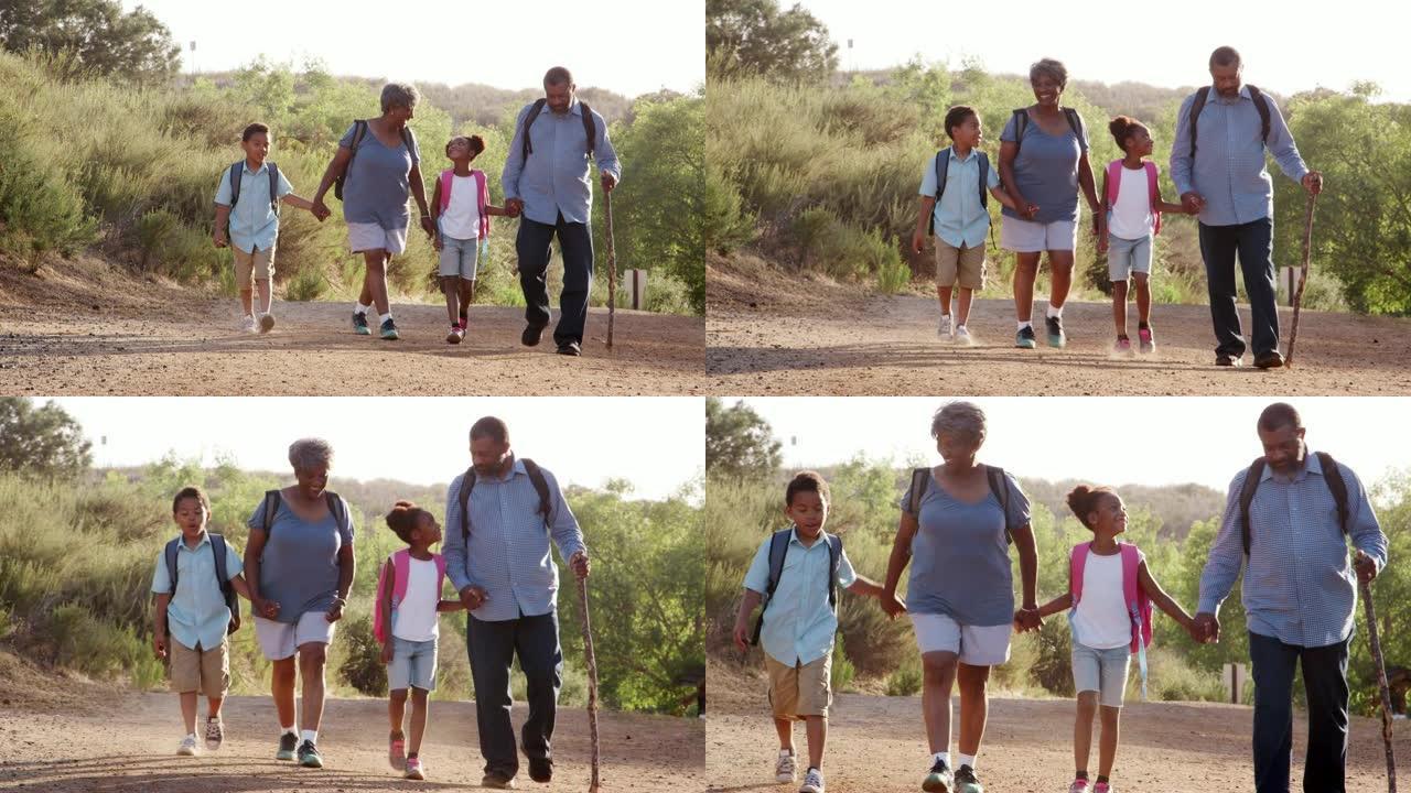祖父母和孙子孙女一起穿着背包在乡下徒步旅行