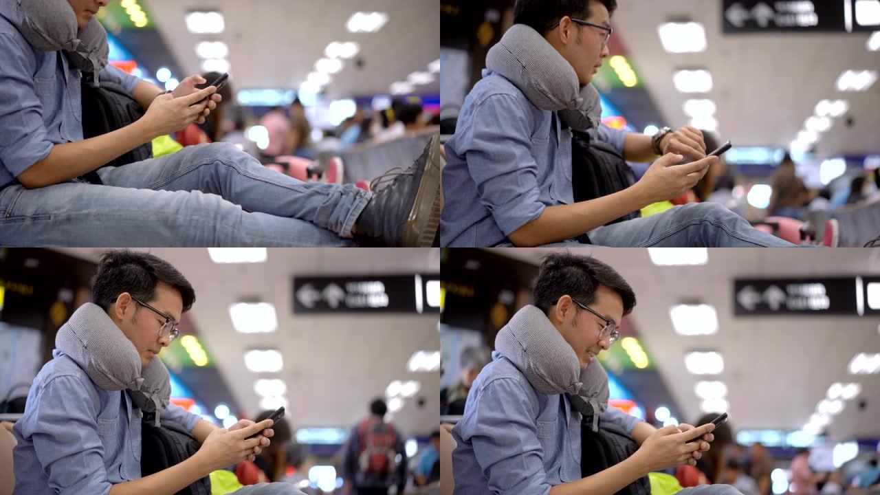 从鞋子平移到在机场等待飞行时使用智能手机的亚洲人的脸