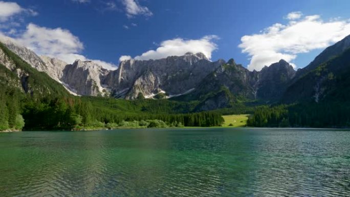 在阳光明媚的日子里，意大利拉戈迪夫辛湖如画的景色。碧绿的湖水荡漾。背景中可以看到覆盖着绿色森林和蓝色