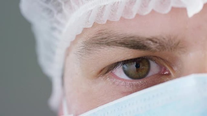 医院或诊所里戴医用口罩、呼吸器、棕色眼睛、手术帽的医生或外科医生的肖像