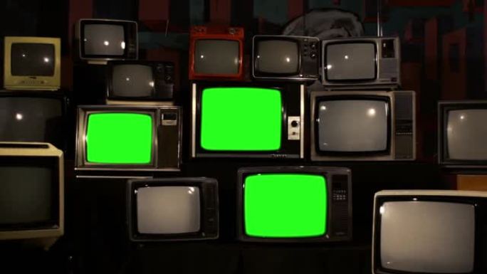 许多打开绿色屏幕的老式电视。烟草色调。