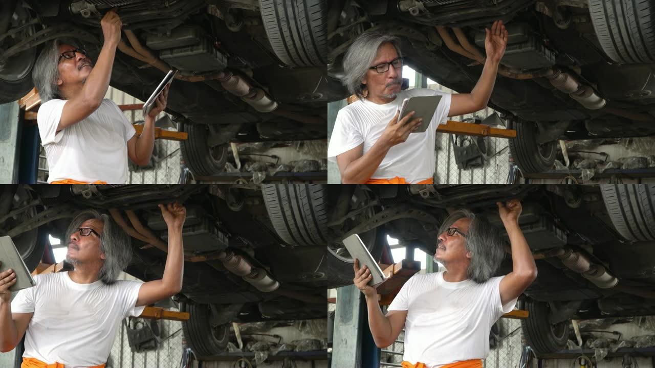 4k: 男性机械师在汽车维修店用平板电脑检查汽车。