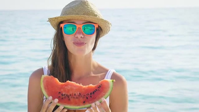 年轻漂亮的女孩在热带地方的海滩上吃热带水果很开心。
