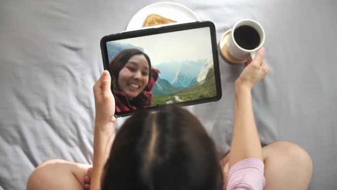 亚洲女性通过数字平板电脑视频通话给朋友