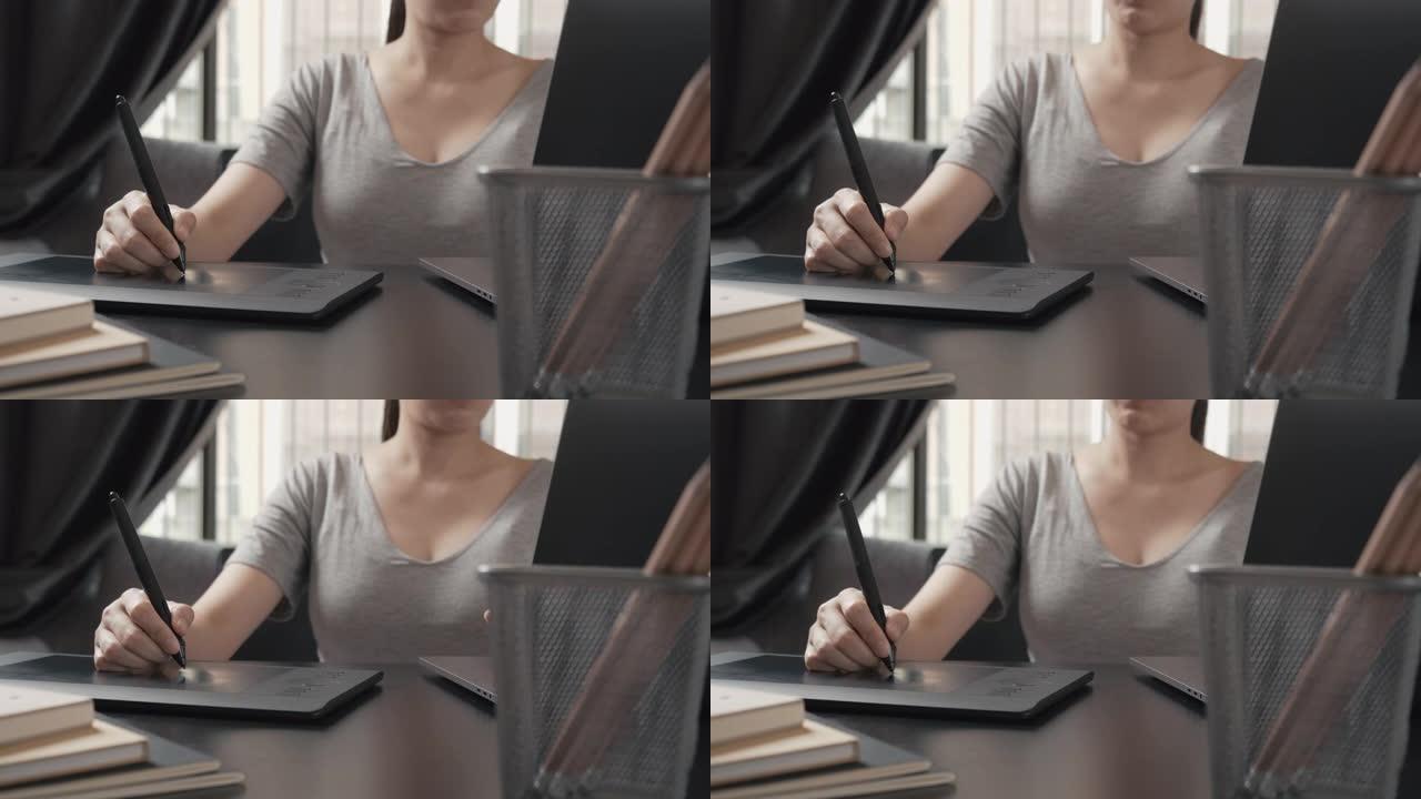 亚洲女性专业平面设计师使用笔记本电脑和数字平板电脑在家庭办公室工作。创意，灵感在家远程工作。