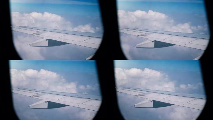从飞行中的飞机窗户座位上可以看到雄伟的宁静景色，飞机机翼在蓝天中飞过惊人的白云。