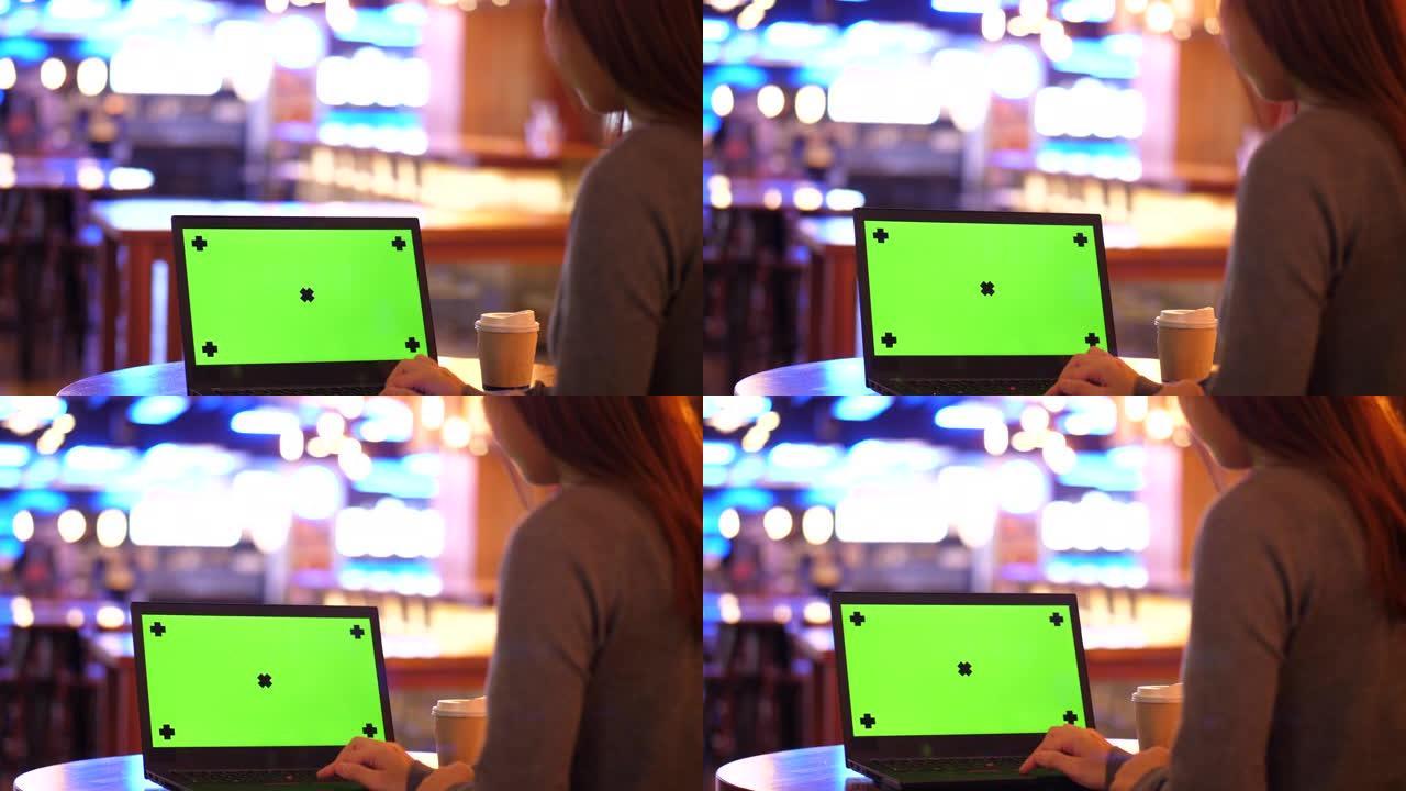 在酒吧使用绿色屏幕的笔记本电脑