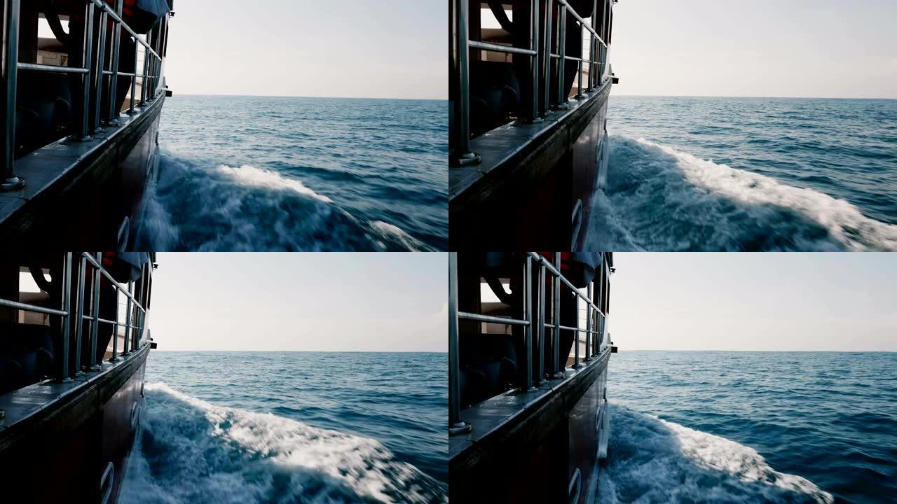 美丽的视点拍摄的巡航游艇船侧在公海快速航行，在晴朗的晴天切割闪亮的蓝色波浪。