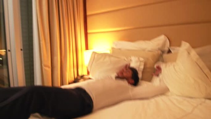 疲惫的商人在酒店房间的床上跳跃