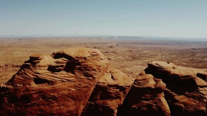 无人机在亚利桑那州纪念碑谷的巨大悬崖上升起，揭示了令人难以置信的无尽广阔的沙漠空间