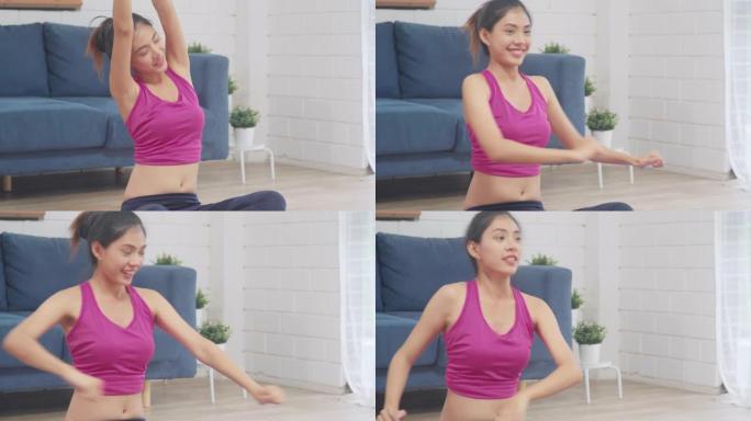 年轻的亚洲女性在客厅练习瑜伽。迷人美丽的女性在家锻炼健康。生活方式女性锻炼概念。