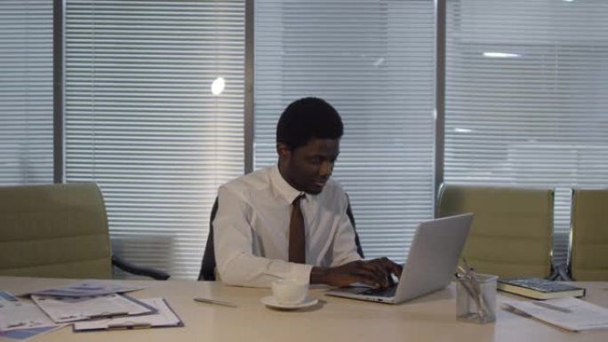 非裔美国人在办公室深夜在笔记本电脑上工作