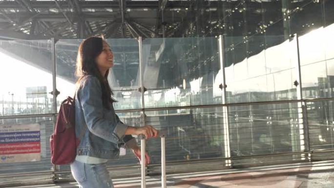 亚洲妇女在机场带着行李旅行