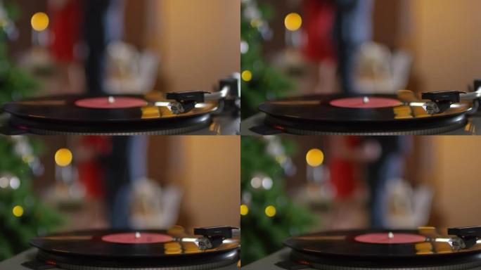 黑胶唱片的演奏和无法识别的情侣在圣诞节跳舞