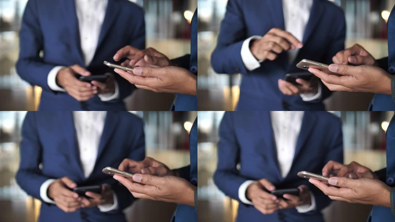 特写两名商人在智能手机共享上使用easy mobile app，午休时同事