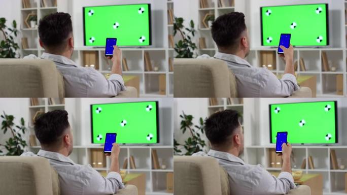 男人使用智能手机和绿屏看电视