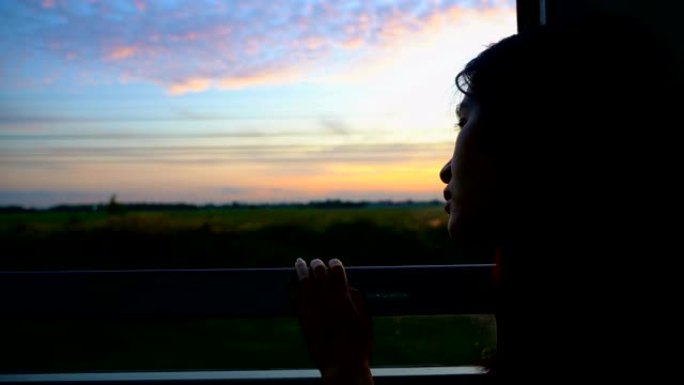 剪影女人早上从火车的窗户看美丽的天空