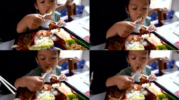 亚洲孩子在当地的房子里吃日本食物。