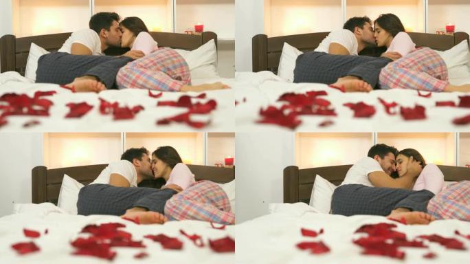 男人和一个女人在床上用玫瑰花瓣亲吻