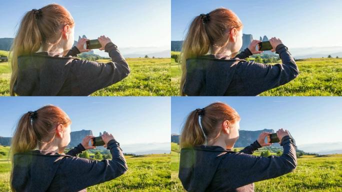 度假的女游客用智能手机拍摄分层山脉的照片