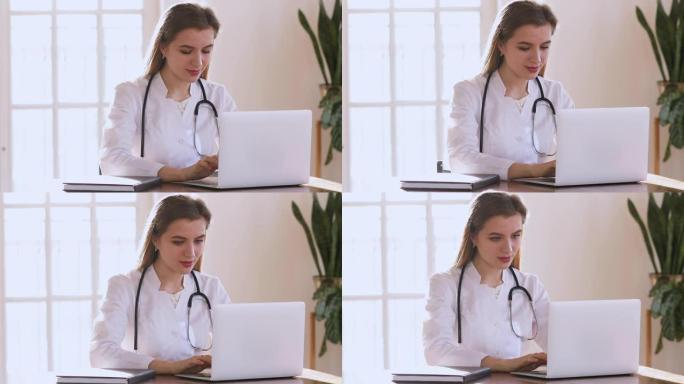 年轻女医生穿白大褂使用笔记本电脑