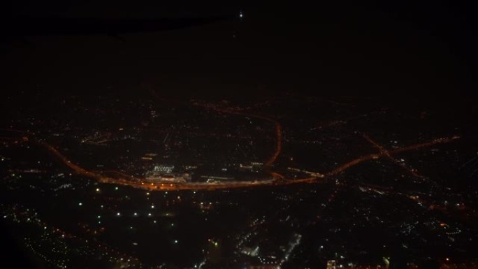 4k镜头场景从机场起飞后，晚上飞机在城市上空飞行的俯视图，旅行和运输概念