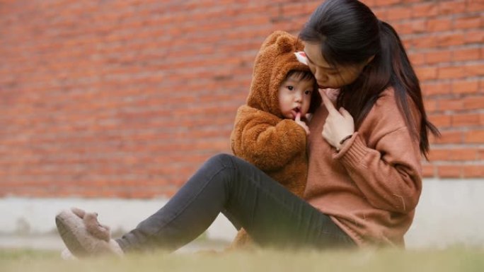 年轻的亚洲妇女带着她的孩子在户外