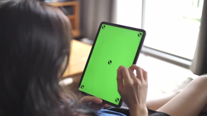 特写女人拿着空白平板电脑，绿屏