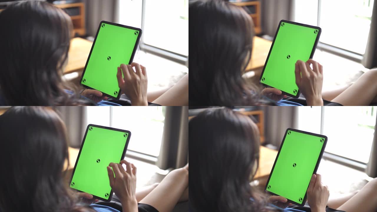 特写女人拿着空白平板电脑，绿屏
