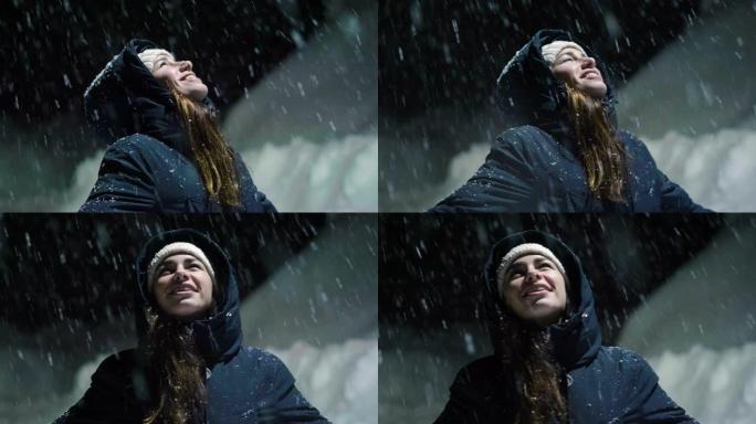 当雪从天而降时，一个美丽的女人在夜晚停在灯光下，开始玩耍，呼吸着干净的空气，在大自然中跳舞。