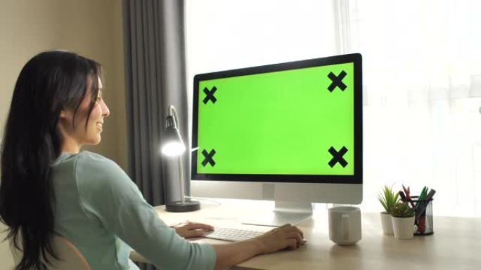 女人使用绿屏电脑显示屏居家办公职场女性