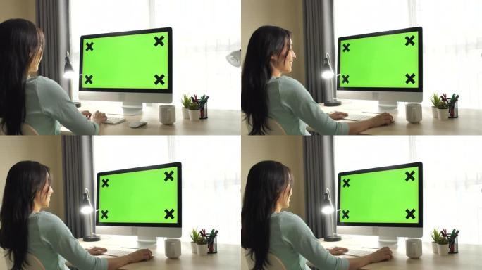 女人使用绿屏电脑显示屏居家办公职场女性