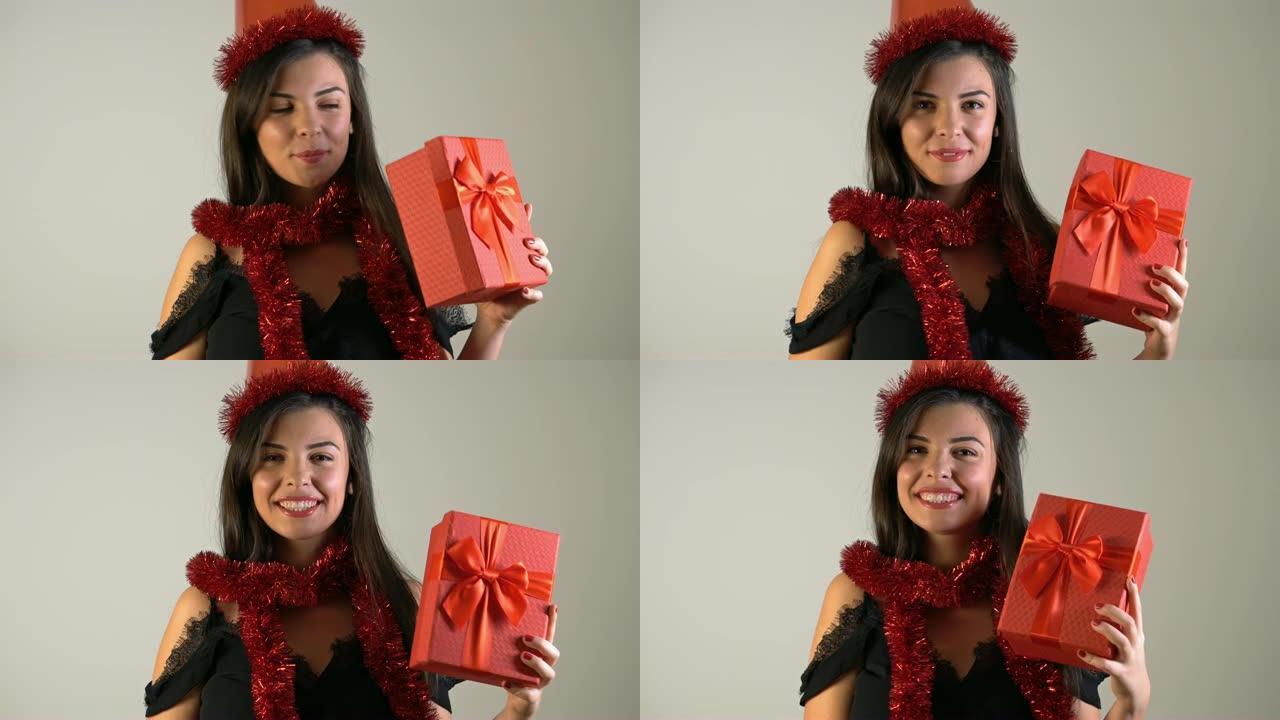 4k圣诞快乐微笑年轻女子手里拿着礼品盒