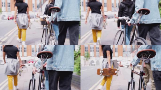 用滑板和自行车穿过城市街道的女性朋友的后视图