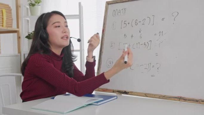 美丽的亚洲女性在线教授数学，微笑的亚洲女性老师在线录制vlog或数学课