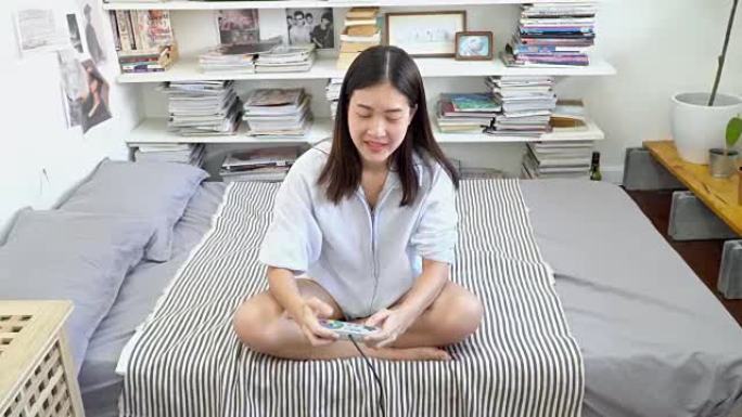 4k; 亚洲女人在床上玩电子游戏。