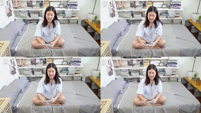 4k; 亚洲女人在床上玩电子游戏。